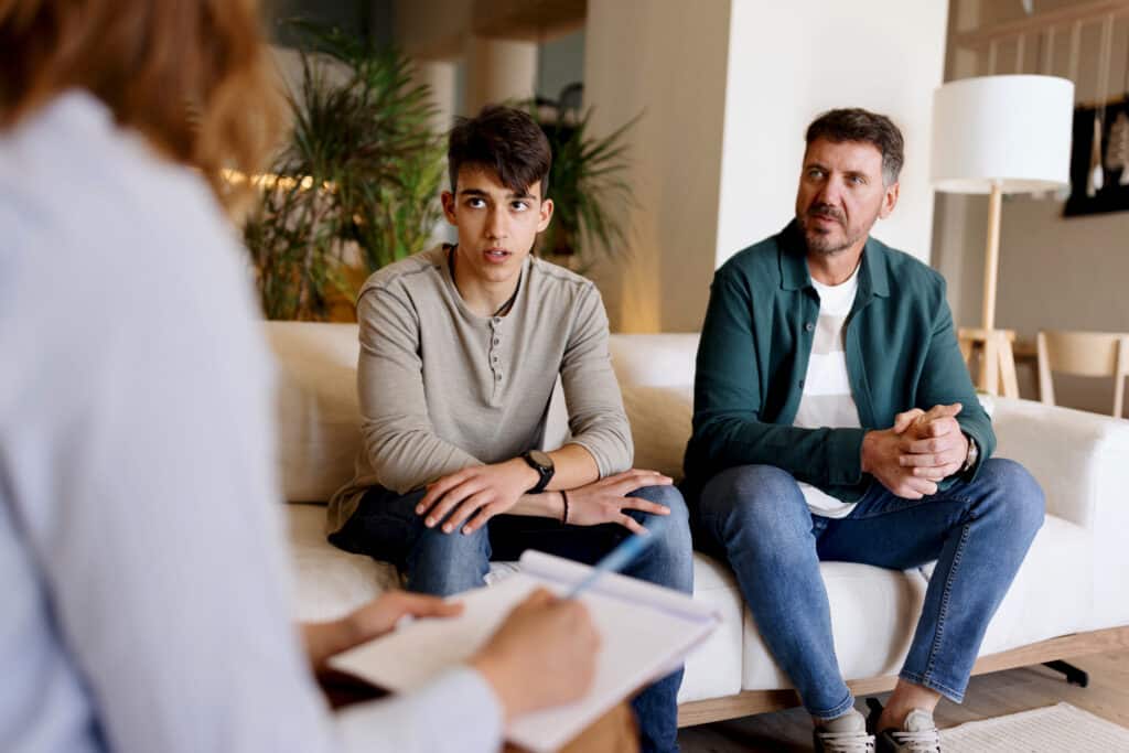 Father and son talking with a psychotherapist
