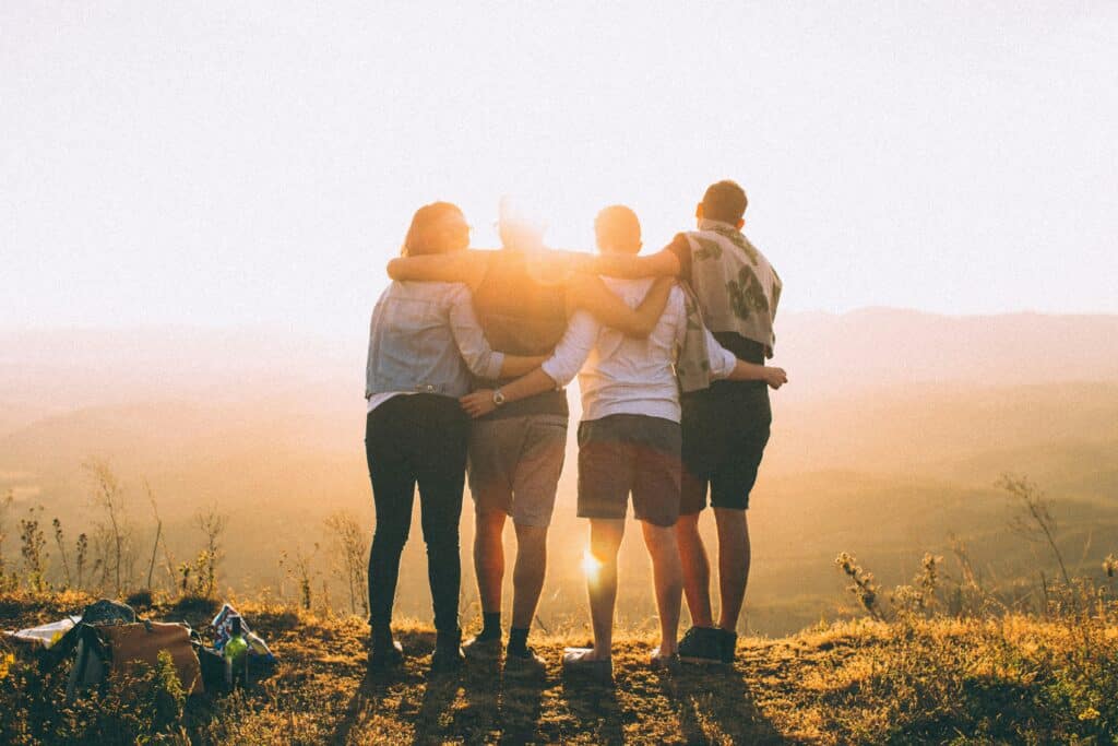 Four young adult friends looking out over mountain view