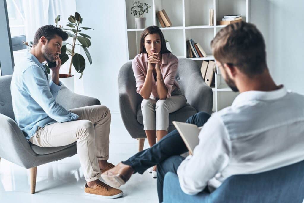 two young adults talking to counselor