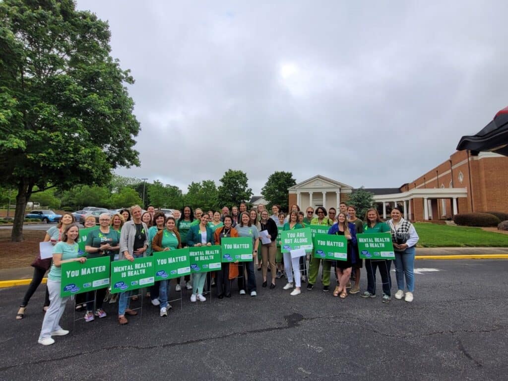one hall go green committee holding signs outside building
