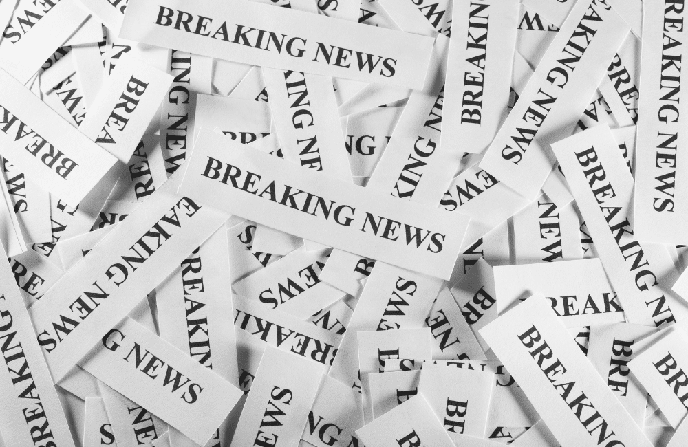 a large pile of strips of paper that all read "Breaking News"