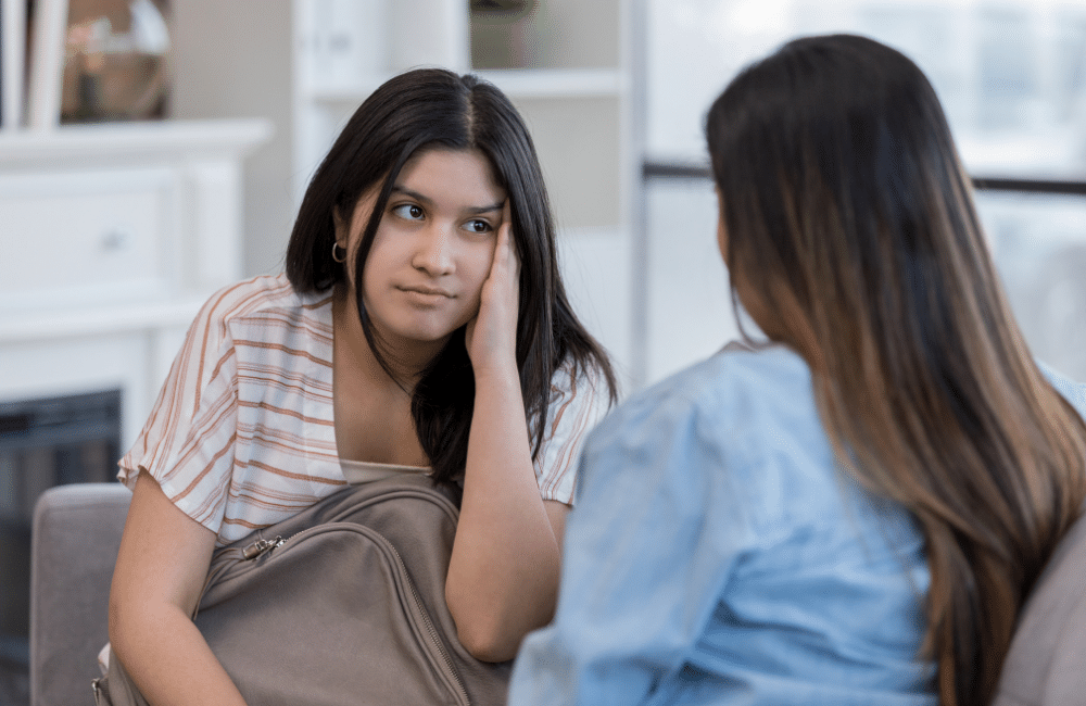 young woman with worried expression talking to friend