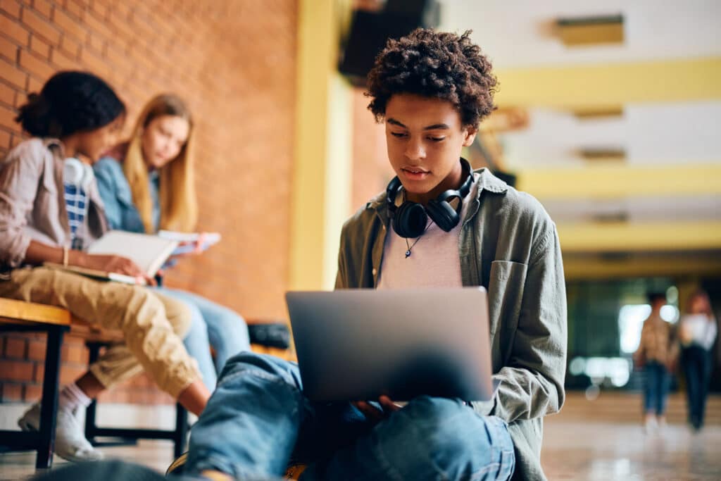 Boy in a school hallway on the computer