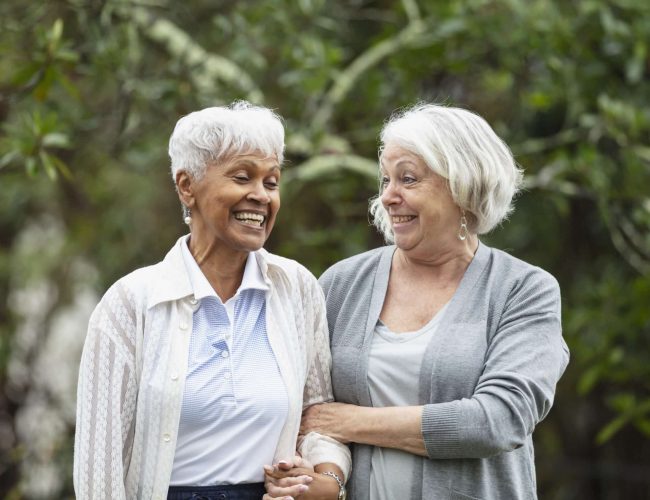 Two senior women walking and talking